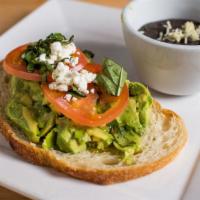 Avocado Mash · Seedful toast stacked with tomatoes, avocado mash, lime, basil and goat cheese crumbles.