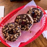 Chocolate Iced Walnuts · Our yeast-raised donut dipped in chocolate icing covered in walnut pieces.  ALLERGEN ALERT!