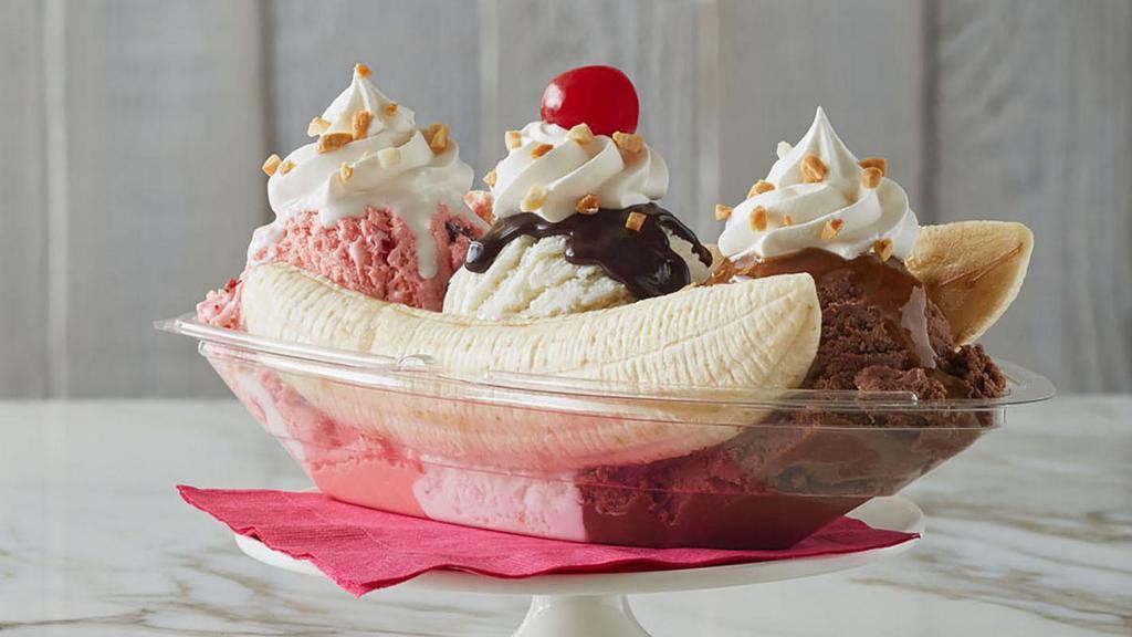Banana Split · Made with vanilla, chocolate, and strawberry ice cream. All nestled between a split banana and dressed with whipped cream, peanuts, and a cherry. Yum.