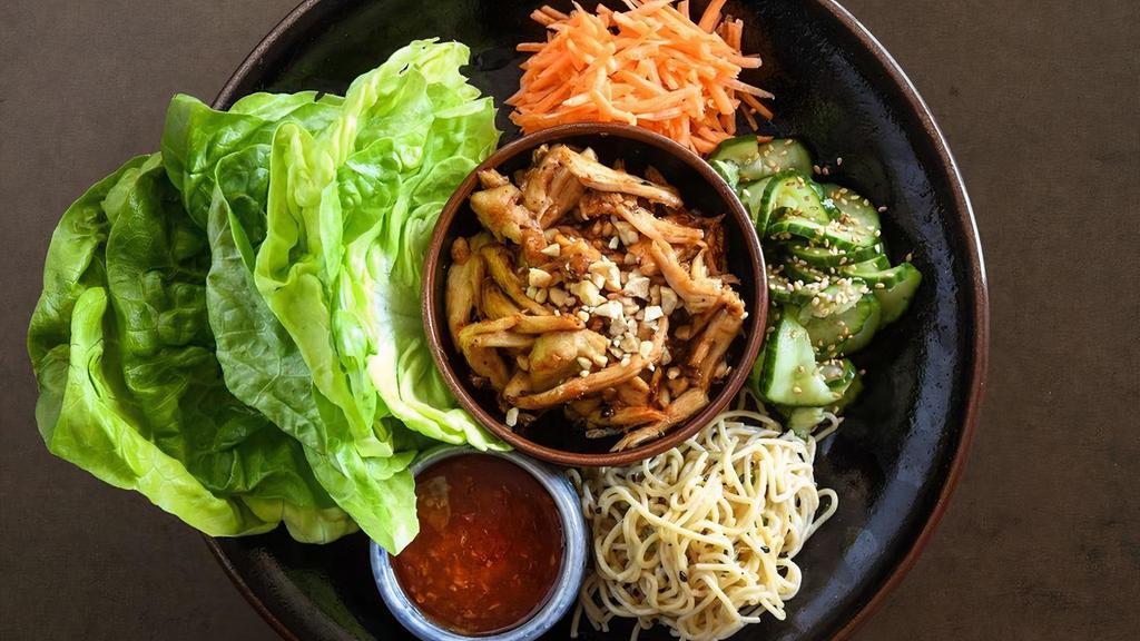 Lettuce Wraps · sautéed all-natural chicken breast with garlic, ginger, cashews and peanut sauce, served with butter lettuce cups, cucumber sunomono, sesame noodles, carrots, crispy rice noodles and sweet chili sauce. tofu available (VG). (VG) tofu available