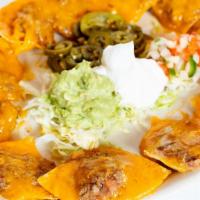 Texas Style Nachos · Tostada chips, beans, cheese, pico de gallo, jalapenos, guacamole & sour cream ,topped with ...