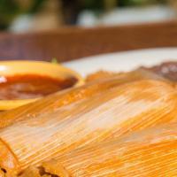 Tamale · Three tamales served with guacamole and chili gravy.