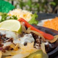 Fajitas Flameadas · Beef or chicken fajitas on a bed of grilled onions topped with chorizo and monterrey jack ch...