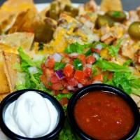 Nachos · chicken, ground beef or combo, tortilla chips, refried beans, cheddar, housemade cheese sauc...