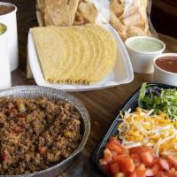 Taco Family Meal · A dozen tacos with your choice of beans, Mexican rice, red & green salsa, queso and chips.