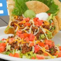 Taco Salad · Tortilla shell filled with seasoned ground beef or salsa-style chicken, lettuce, tomatoes, g...