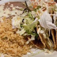 Tamataco · Two chicken tamales with Chile cone carne sauce and one crispy taco. Served with rice and be...