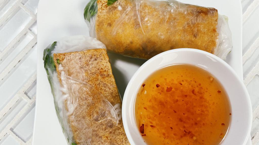 Tofu Spring Rolls · Tofu rice wrapped spring rolls with light veggies on a bed of noodles. Includes a dipping fish sauce.