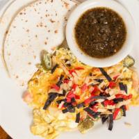 Migas · Scrambled eggs, tortilla strips, jalapeños, tomatoes, and onion, topped with Cheddar cheese ...