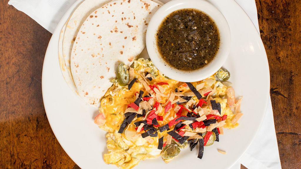 Migas · Scrambled eggs, tortilla strips, jalapeños, tomatoes, and onion, topped with Cheddar cheese and served with tortillas and salsa.