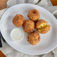 Mac & Cheese Balls · Gooey deep fried mac and cheese served with ranch and honey sriracha.