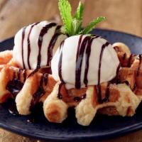 Warm Belgium Waffle W/Ice Cream · Warm Belgian waffle served with vanilla ice cream and a drizzle of chocolate sauce.