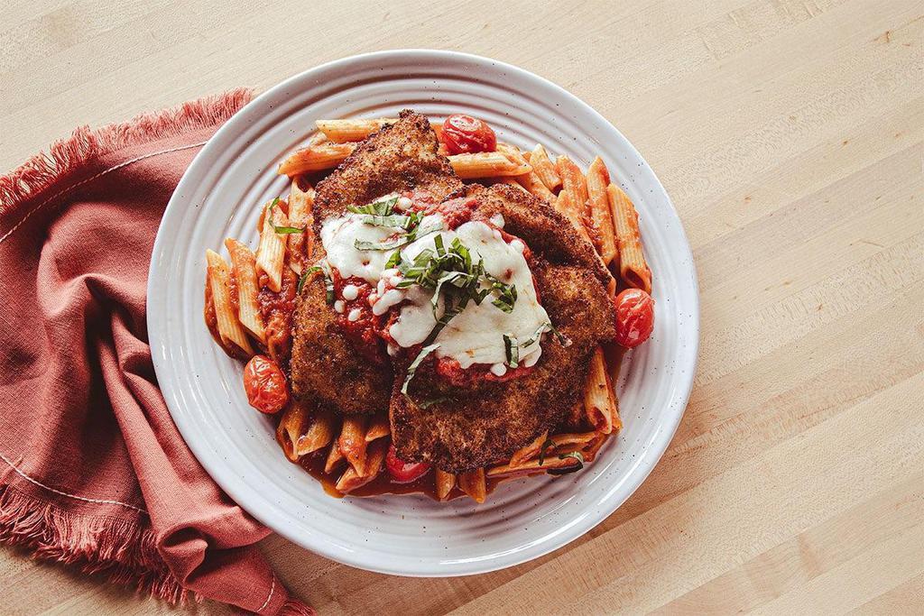 Chicken Parmigiana · Wow, chicka, wow, wow! Crunchy Italian breaded chicken topped with blistered tomatoes, fresh mozzarella and basil, with our signature marinara and penne pasta.