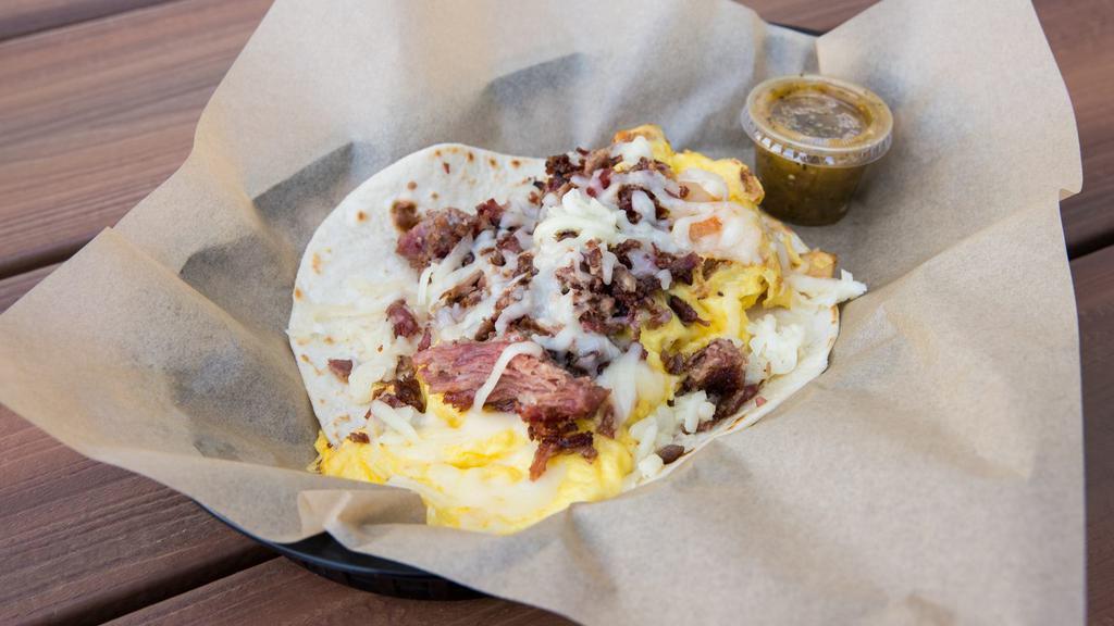 Wrangler · Scrambled eggs and potatoes topped with smoked beef brisket and jack cheese. Served with TOMATILLO SAUCE on a flour tortilla. Dairy, Soy, Eggs, Gluten. *Flour tortillas contain Gluten. *Scrambled eggs contain Dairy