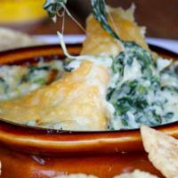 Spinach Artichoke Dip · Homemade dip served warm and gooey with white corn tortilla chips.
