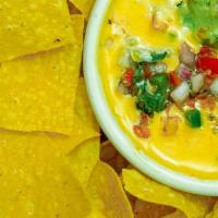 Chips & Queso · Tostada chips served with homemade queso - creamy melted cheese topped with taco meat, guaca...