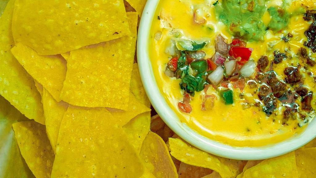 Chips & Queso · Tostada chips served with homemade queso - creamy melted cheese topped with taco meat, guacamole & pico de gallo
