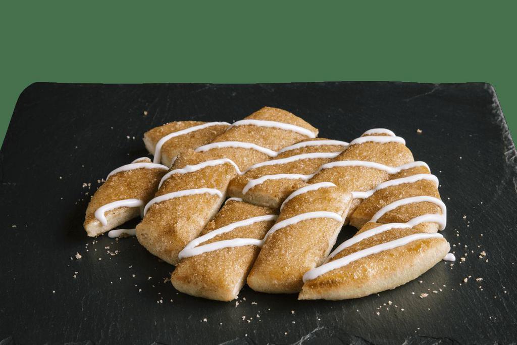 Cinnamon Sticks · The name says it all. Our freshly baked breadstix topped with cinnamon, sugar and drizzled with icing.You’ll want to eat the whole thing! That’s okay, do it!