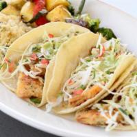Fish Tacos · Panko-crusted, flat-grilled tilapia with fresh cabbage slaw and cilantro-lime aioli in house...