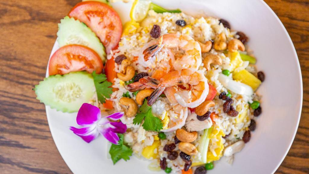 Pineapple Fried Rice · Chicken, shrimp, pineapples, toasted cashews, tomatoes, onions, scallions, raisins, peas and carrots.