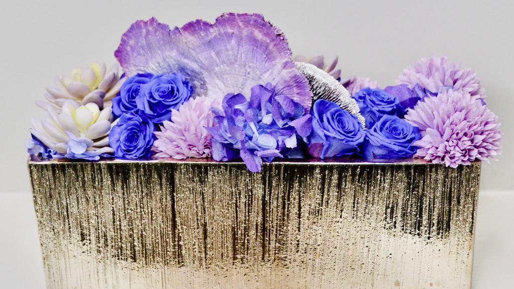 The Cher · Make a statement for Mom this Mother's Day with an assortment of silver and purples. This beauty features our signature preserved roses, hydrangea, tree mushrooms and faux succulents.