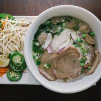 Pho Noodle Soup · Traditional beef noodle soup served with a side of bean sprouts and basil leaves.