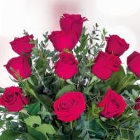 Dozen Red Roses · One dozen standard red roses beautifully arranged in a clear vase with mixed greenery, accen...