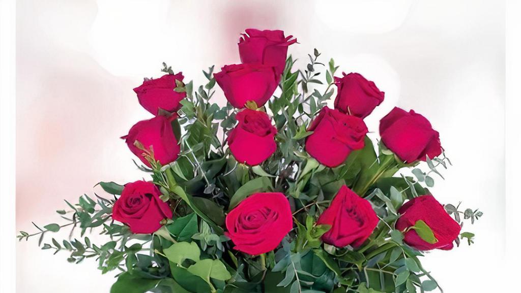 Dozen Red Roses · One dozen standard red roses beautifully arranged in a clear vase with mixed greenery, accented with river rocks.

Approx. 18