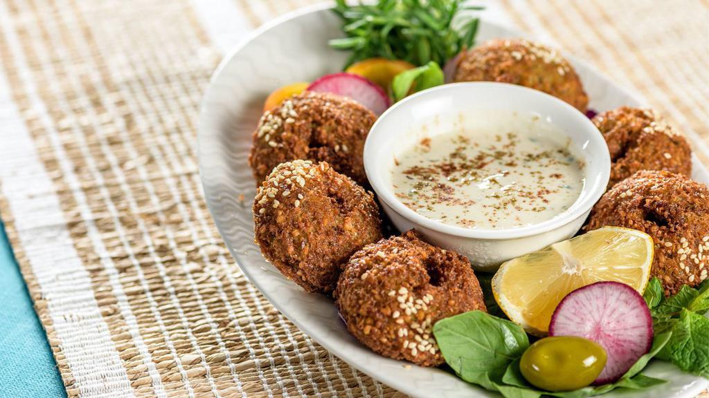 Spicy Falafel Bowl · A bowl of fresh, spiced falafel balls with hummus, tabouli, green salad, and dolma. Topped with chef's spicy sauce.