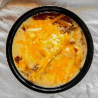 Tamale Pie · Layered with fritos, tx beef chili, queso and your choice of  two tamales. Topped with shred...