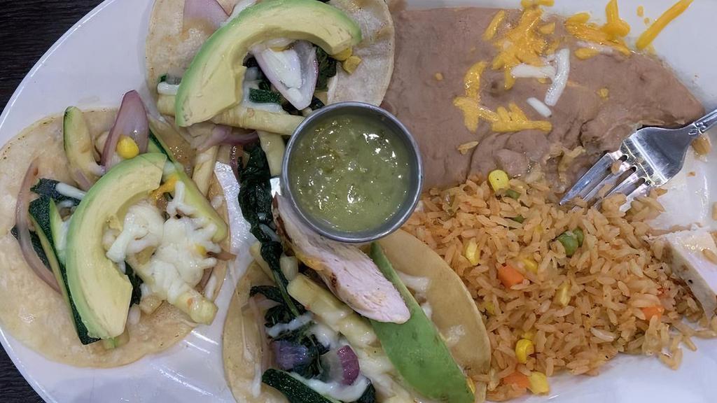 Veggie Tacos · Soft corn tortilla topped with sautéed garlic, spinach, onions, bell peppers, cheese, cilantro and fresh avocado.