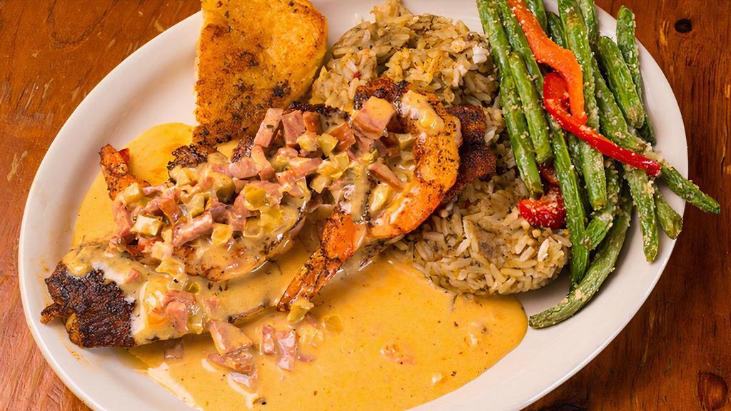 Togo Rockdale Redfish · Blackened Redfish and Jumbo Blackened Gulf Shrimp topped with Zesty Andouille Cream Sauce. Served with choice of Veggie, and choice of dirty or white rice.