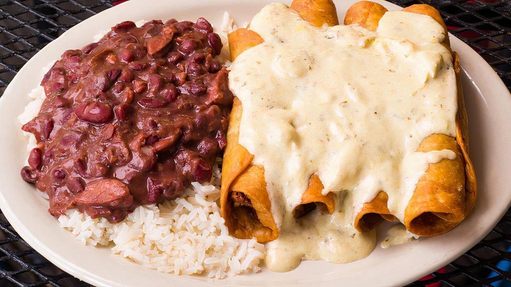 Togo Boudin Flautas · Homemade Boudin and Pepper Jack Cheese wrapped in a Flour Tortilla, fried to perfection, and topped with sautéed Crab Meat in a Verde Cream Sauce. Served with Red Beans and Rice.