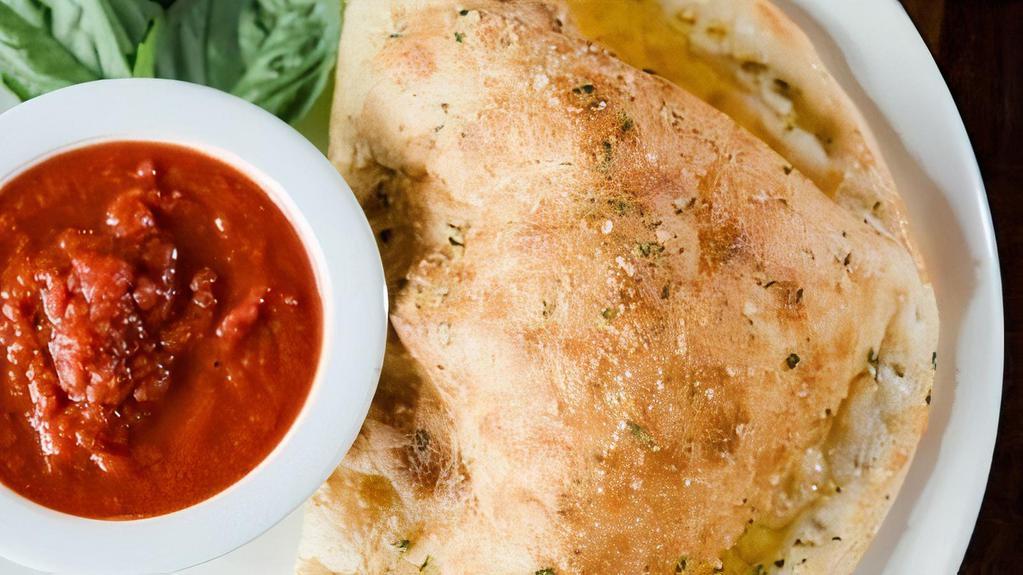 Build Your Own Calzone · Oven-baked dough stuffed with your choice of toppings. Brushed with garlic butter and parmesan, and served with marinara.