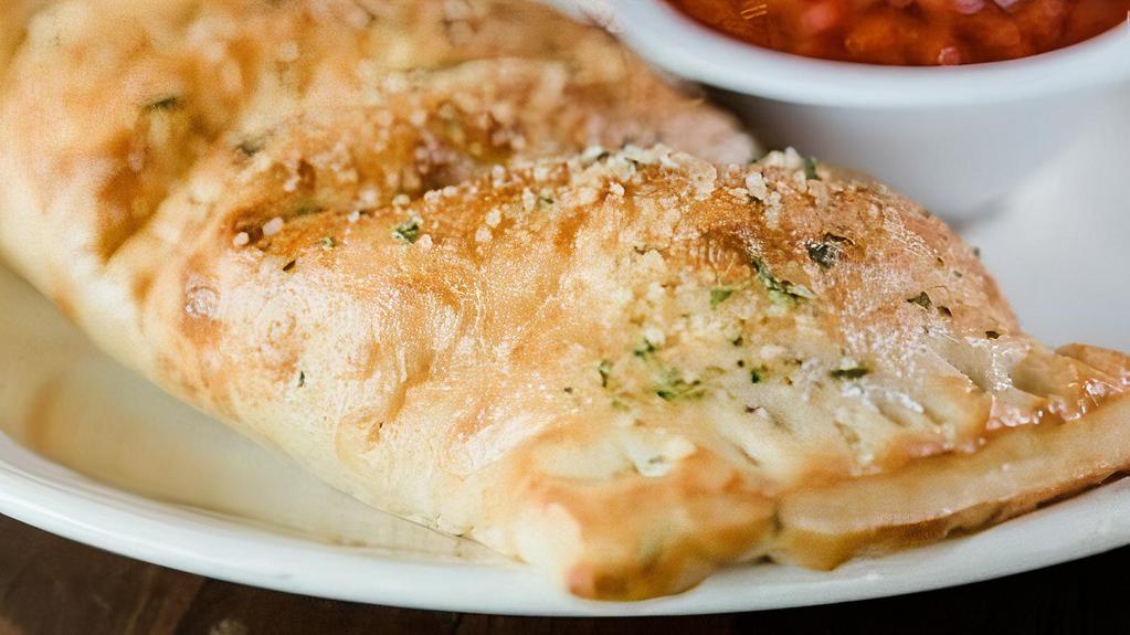 Meat Stromboli · Oven-baked dough stuffed with pepperoni, sausage, hamburger, Canadian bacon, bacon, and mozzarella cheese. Brushed with garlic butter and parmesan, served with marinara.