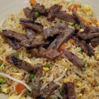 Beef Fried Rice · White rice stir-fried in soy sauce with eggs, carrots, peas and bean sprouts topped with beef.
