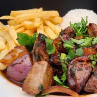 Lomo Saltado · Marinated sliced steak w/onions, tomatoes, soy sauce, served w/rice, French fries, and a sal...