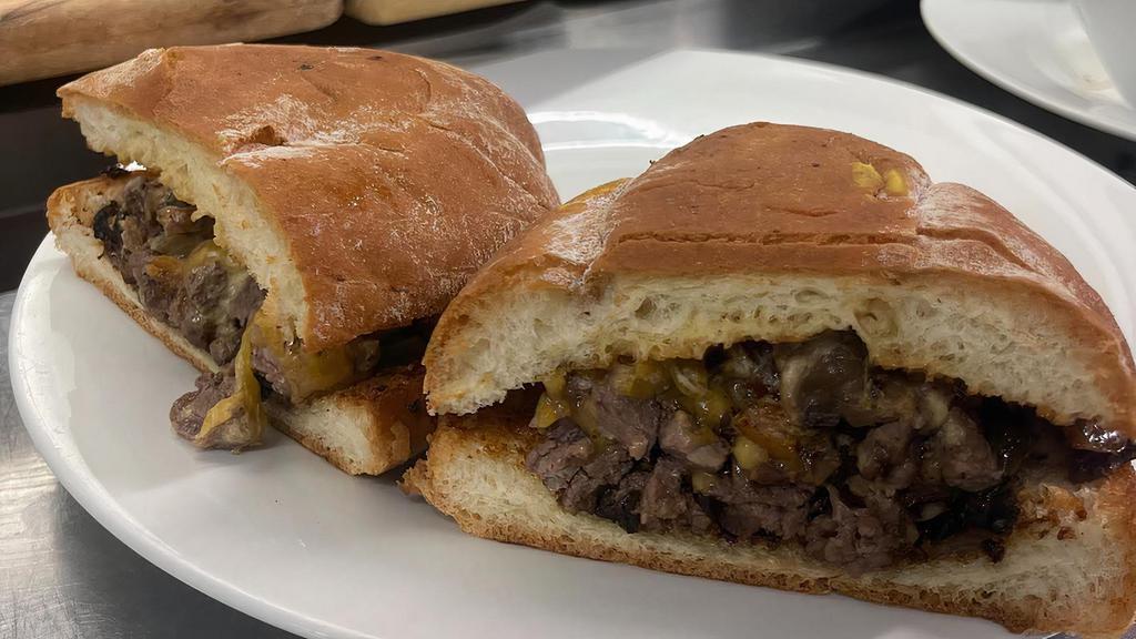 Philly Cheese Torta · Mexican Torta Bread, Beef fajitas, cremini mushrooms, bell peppers, onions, jalapeno cheese sauce  and cheddar cheese.