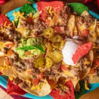 Cantina Nachos · Table side chips served with beans, ground beef, chile con queso, guacamole, tomatoes, jalap...