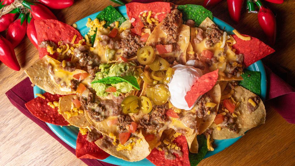 Cantina Nachos · Table side chips served with beans, ground beef, chile con queso, guacamole, tomatoes, jalapeños and sour cream.