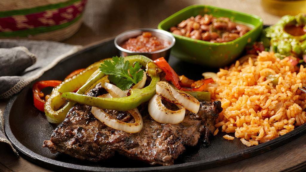 Steak Ranchero · A marinated Angus Beef Fajita Steak topped with sauteed bell peppers and onions. Served with rice, borracho beans. guacamole, and ranchero sauce.
