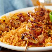 Shrimp En Fuego · Fire-grilled shrimp skewers glazed with our mix of garlic and chiles, served with rice and b...