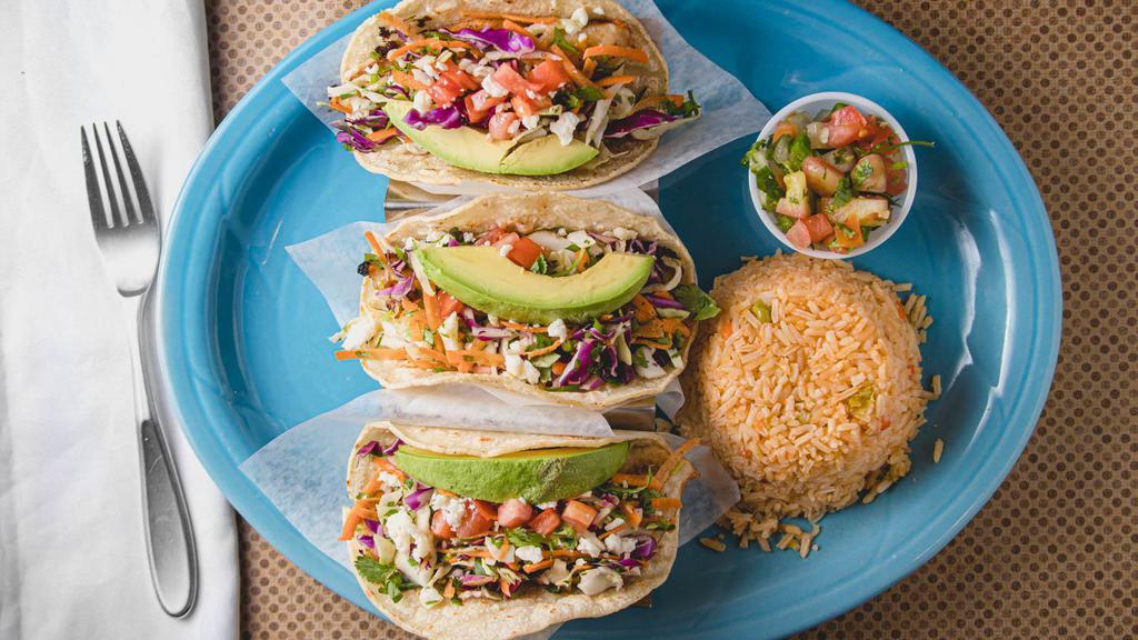 Fish Tacos · Grilled or fried fish in corn tortillas, topped with a mix of cabbages, rice, and pico de gallo.