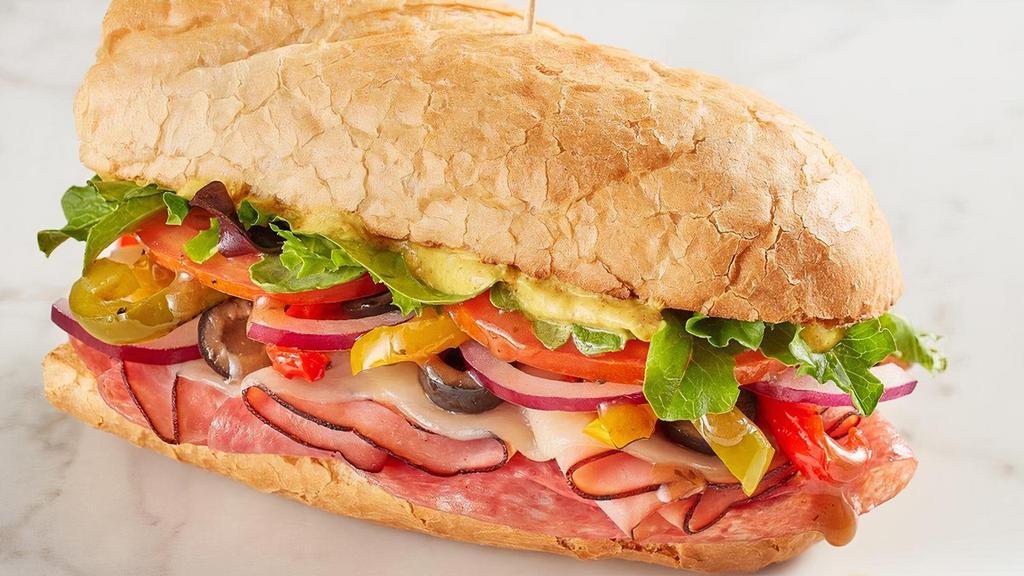 The Italian · Black Forest ham, salami, provolone, house-roasted multicolored peppers, spring mix, tomato, red onion, black olives, Olive Oil & Balsamic Vinaigrette and spicy brown mustard on baguette.