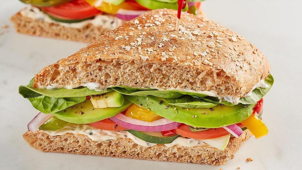 The Veggie · Spinach, tomato, cucumber, red onion, house-roasted multicolored peppers, avocado and herb mayo on 9-grain.