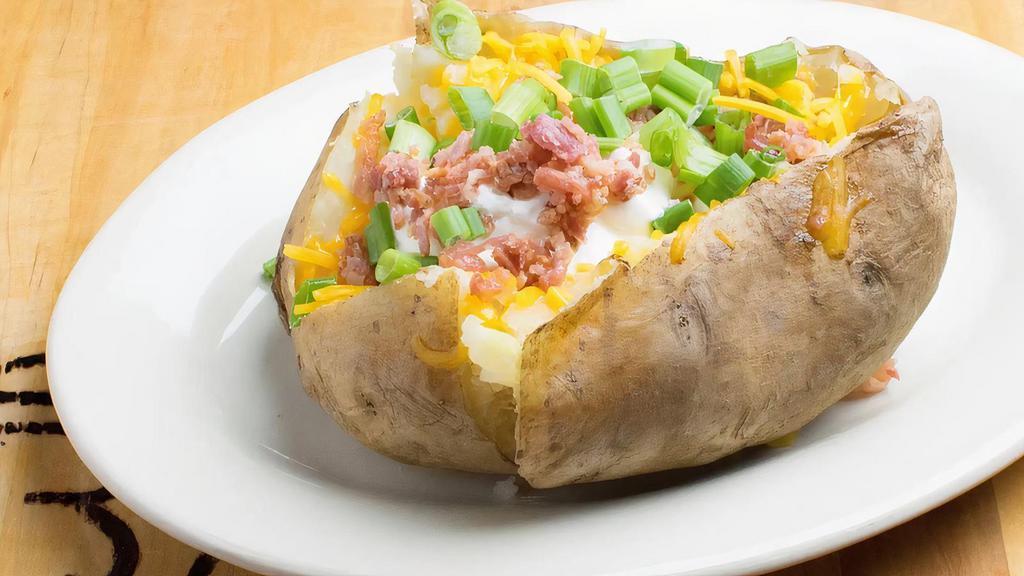 Baked Potato · Texas sized Baked Potato made w/ Real Bacon, Butter, Fresh-Cut Chives, Cheddar Cheese, and Sour Cream