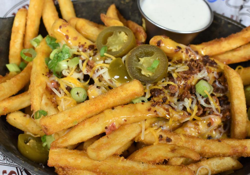 Locked & Loaded Cheese Fries · Crispy fries fried high, smothered with jack, cheddar and spicy queso cheese then topped off with bacon, chives and jalapenos. Served with ranch.