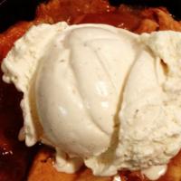 Two Rows Peach Cobbler · Fresh peach cobbler topped with a scoop of vanilla bean ice cream.