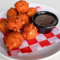 Hush Puppies · Deep fried cornbread nuggets with fresh jalapeños and yellow corn. Served golden brown.