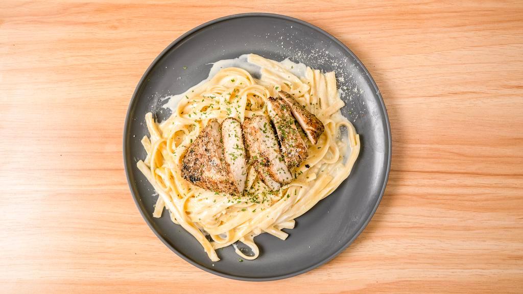 Chicken Fettuccine Alfredo · fettuccine noodles tossed in our house made alfredo sauce topped with our spiced grilled chicken and parmesan cheese. served with a garlic knot and side salad